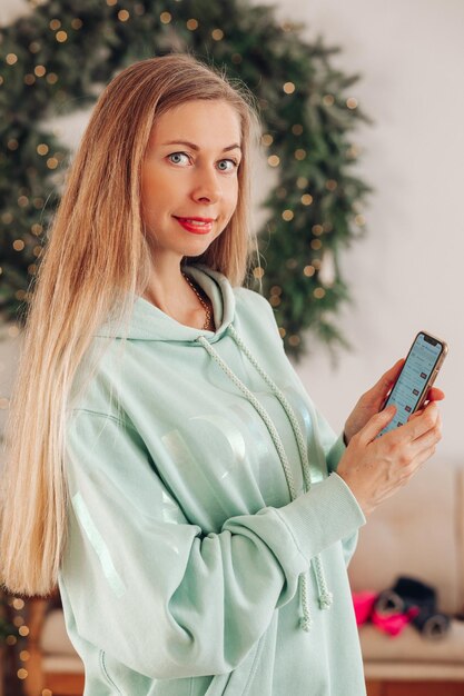 A woman with a phone in her hands a woman with long hair shows an application on a mobile phone