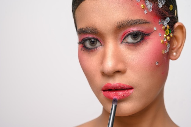 Free photo a woman with pink makeup and lipstick on her lips isolated on white