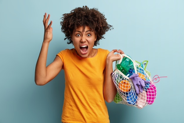 Free photo woman with plastic waste in net bag