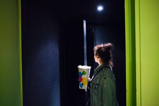 Free photo woman with popcorn in cinema theatre