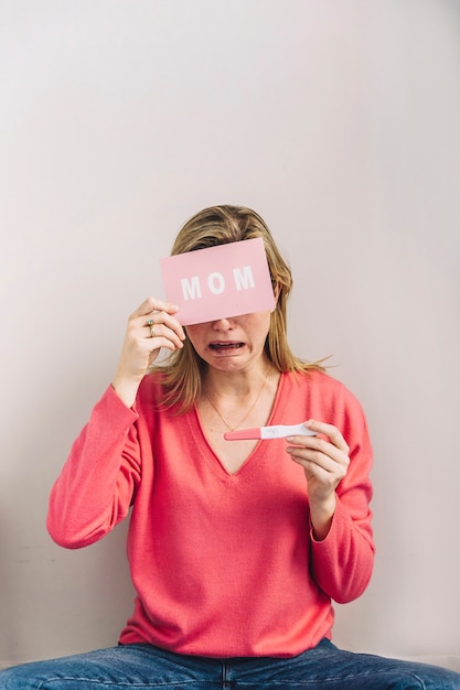 Free photo woman with pregnancy test and card