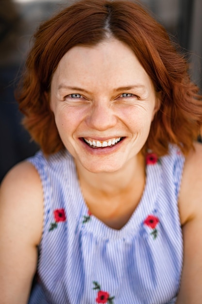 Free Photo woman with red hair in a cafe drinks a summer cocktail, happy, laughs, smiles.