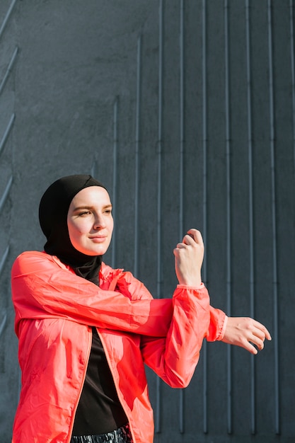 Woman with red jacket stretching