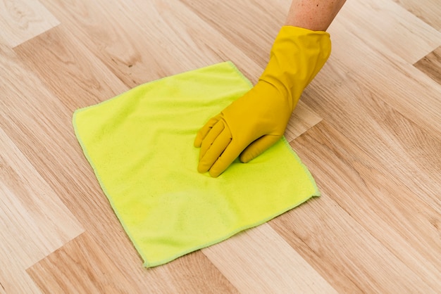 Woman with rubber glove cleaning the floor