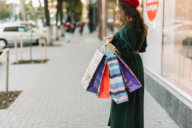 Free photo woman with shopping bags at case on street