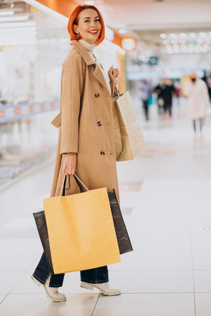 Woman with shopping bags making purchases in mall