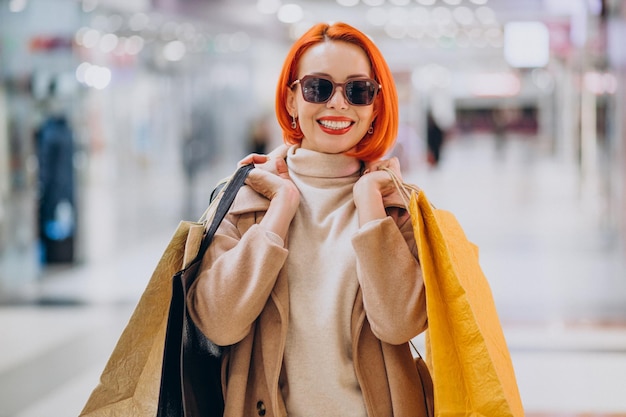 Woman with shopping bags making purchases in mall