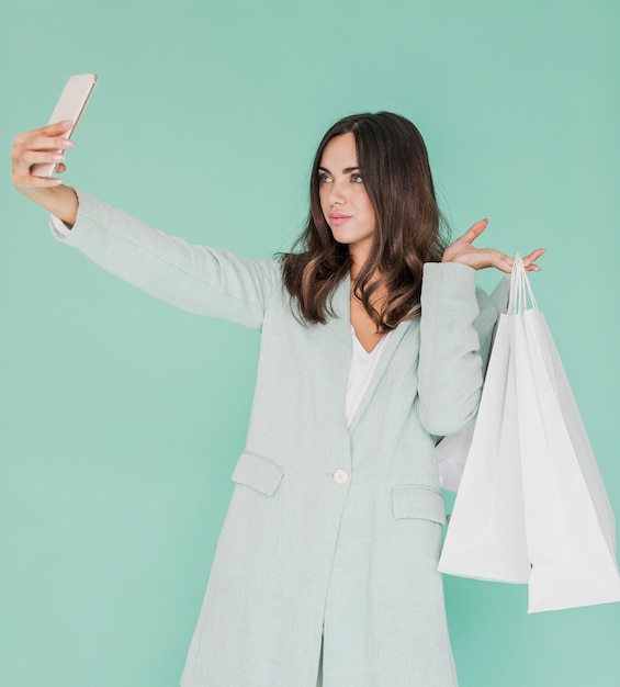 Free Photo woman with shopping bags taking a selfie