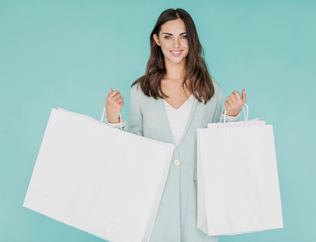 Free Photo woman with shopping nets on blue background