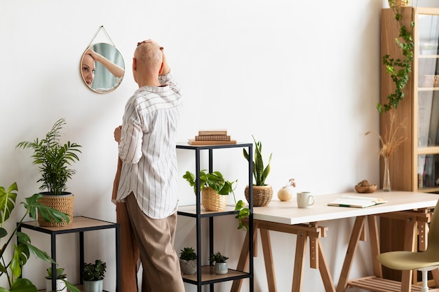 Free photo woman with skin cancer looking in the mirror