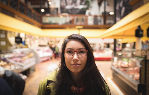 Woman with specks standing in the supermarket