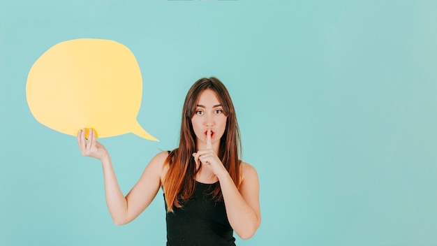 Free photo woman with speech bubble showing silence gesture