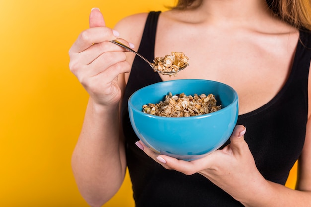 Woman with spoon and bowl of flakes