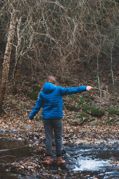 Free Photo woman with stick crossing river