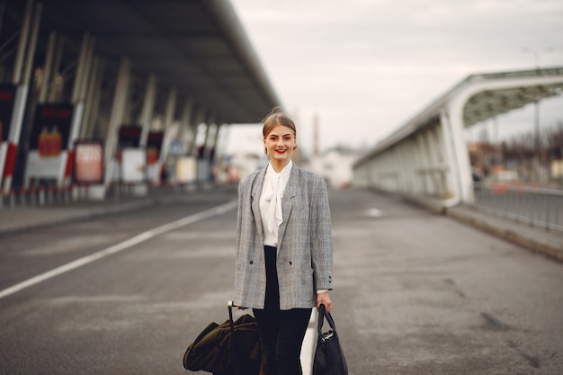 Free Photo woman with suitcase standing by the airport