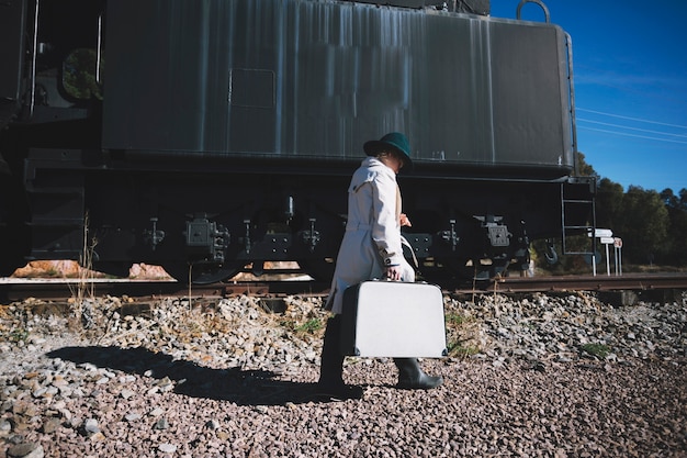 Free photo woman with suitcase walking to train