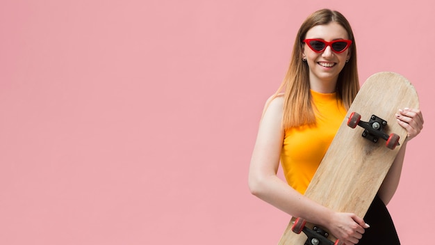 Free photo woman with sunglasses and skateboard