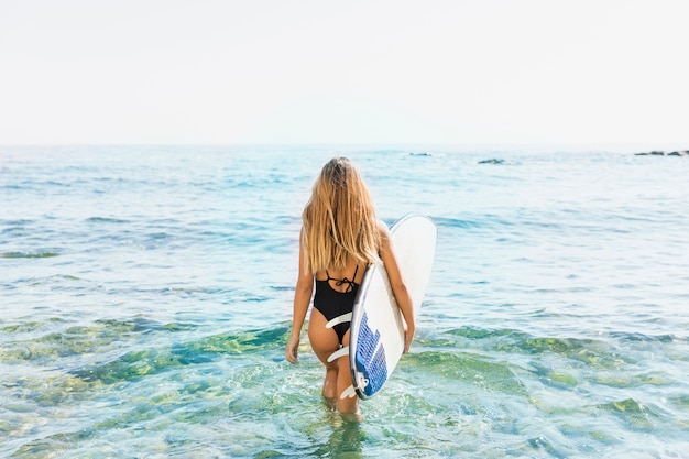 Free photo woman with surfboard at the beach