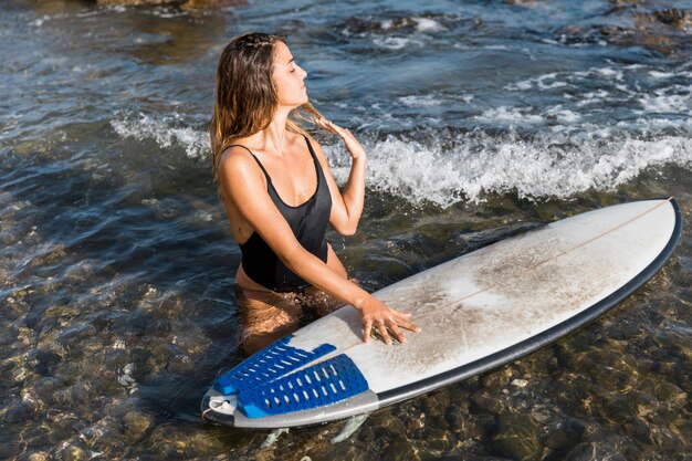 Woman with surfboard at the beach