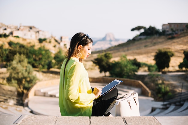 Woman with tablet on steps