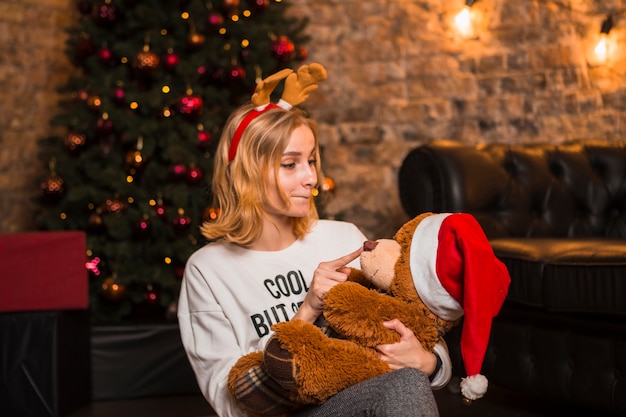 Free photo woman with teddy bear in arms