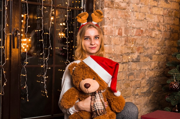 Free Photo woman with teddy bear at christmas