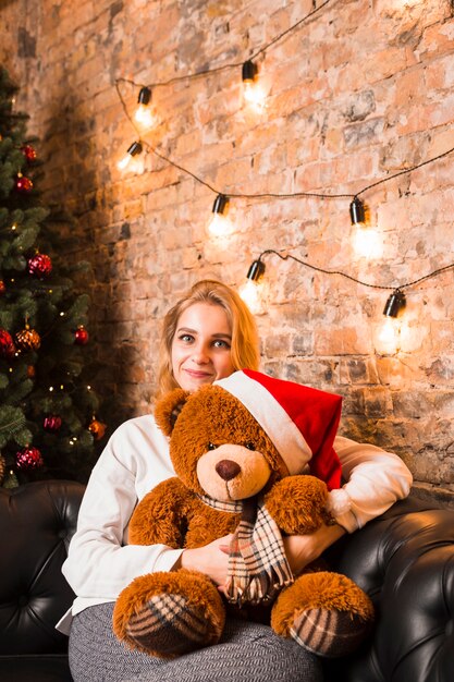 Woman with teddy bear wearing christmas hat