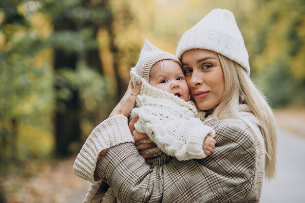 Woman with toddler child in autumn park