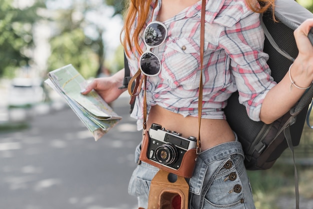 Free Photo woman with vintage camera and map