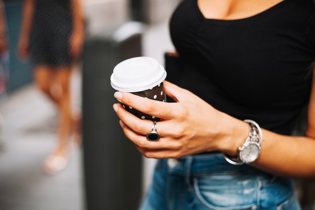 Free photo woman with watch holding coffee cup