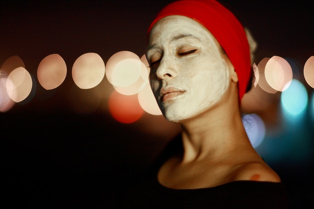 Free photo woman with white face and red ribbon