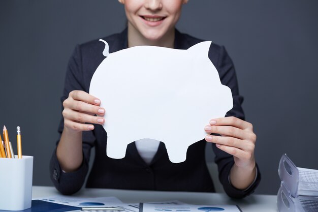 Woman with a white piggy bank