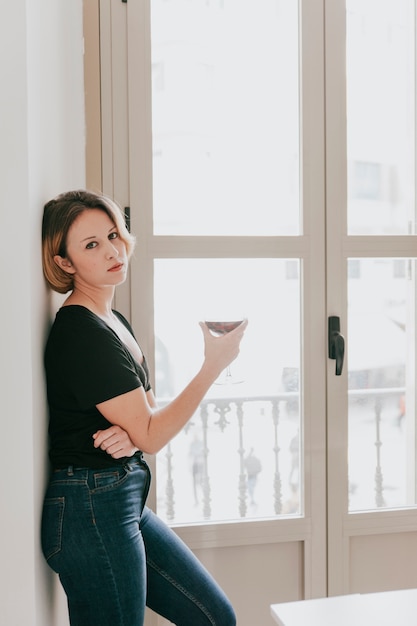 Free Photo woman with wine at window