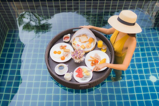 woman with with breakfast floating around swimming pool