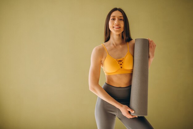 Woman with yoga mat practising yoga