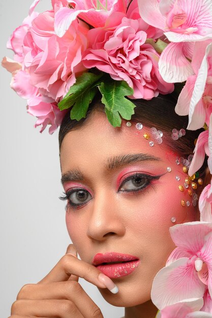 Woman wore pink makeup and beautifully decorated the flowers isolated on white