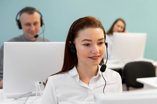 Free photo woman working in call center office with headphones and computer