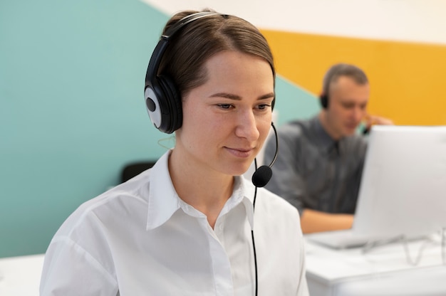 Free photo woman working in call center office with headphones and computer