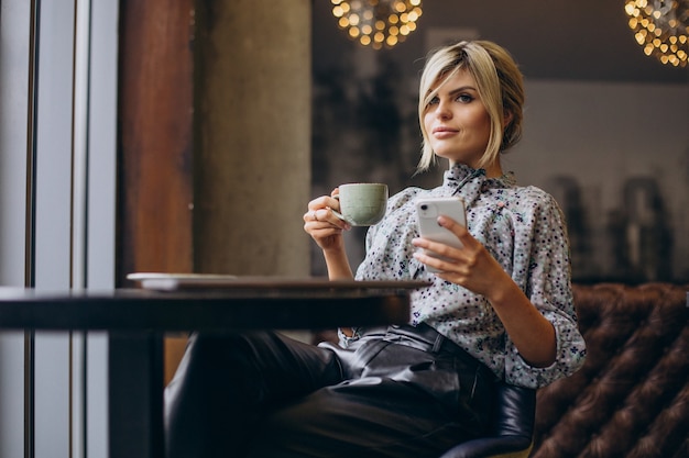 Woman working on computer and drinking coffee