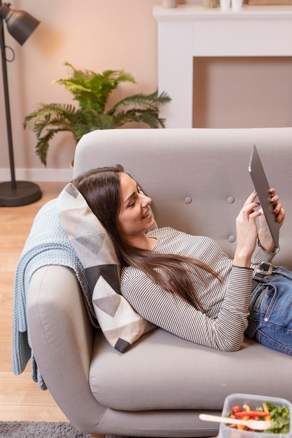 Woman working on digital tablet and food on table