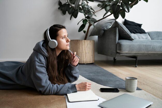 Woman working on the floor from home with device