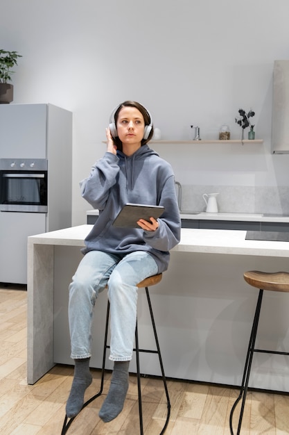 Woman working from home kitchen with tablet