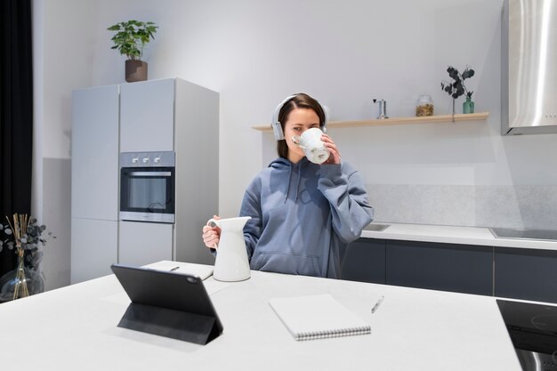 Woman working from home kitchen with tablet