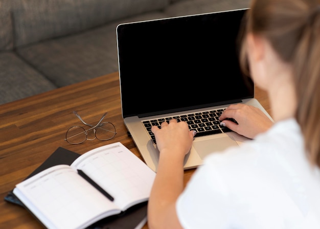 Woman working from home for social distancing with notebook and laptop