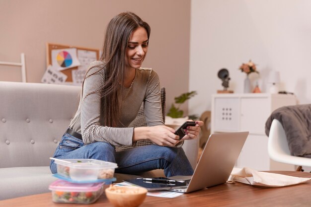 Woman working and having lunch boxes next to her