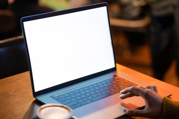 Free photo woman working on her blank laptop in a coffee shop