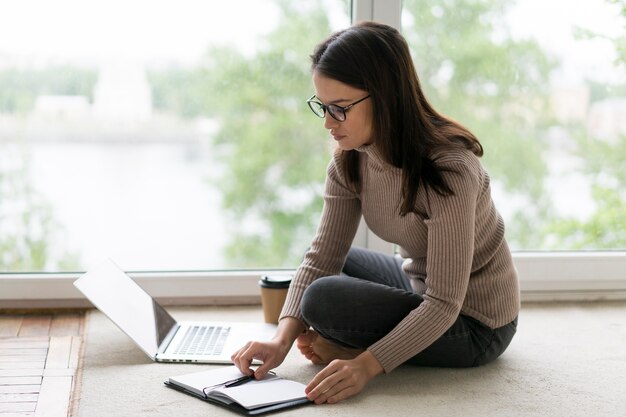 Woman working on her laptop on the floor