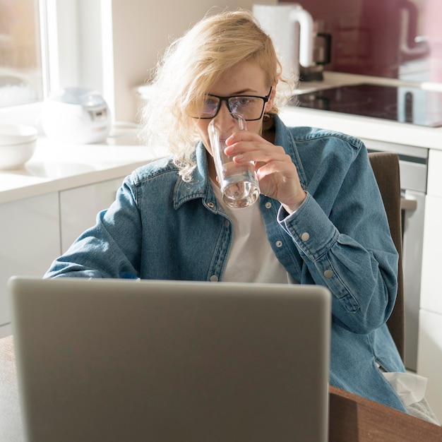 Woman working on laptop and drinking water