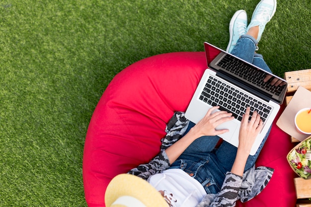 Free Photo woman working on laptop and eating salad