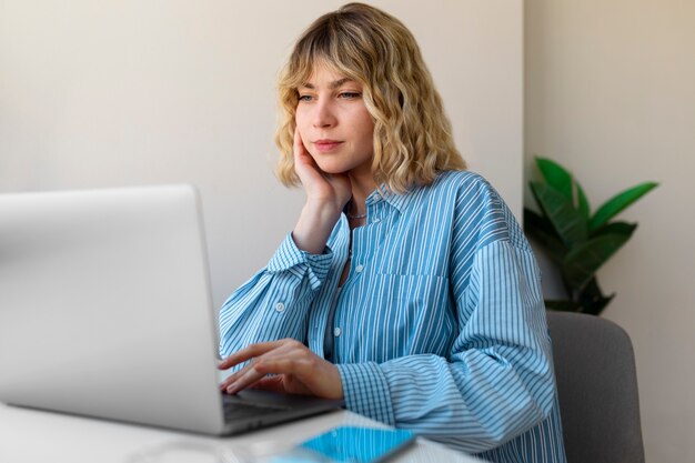 Woman working on laptop side view